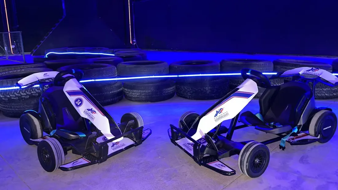Dos karts Segway en la pista techada, iluminada con LED azul